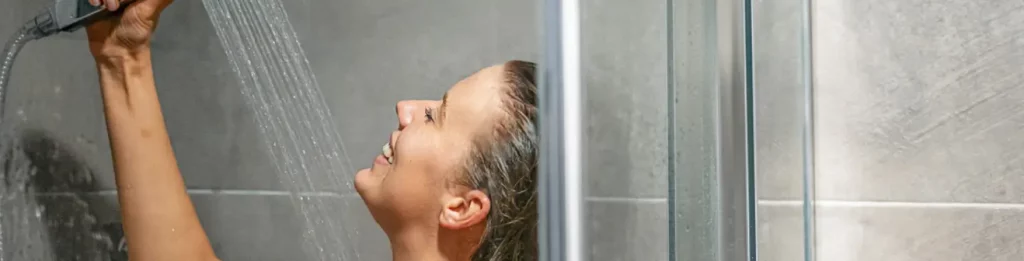 woman enjoying hot shower because of her condensing hot water heater